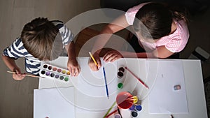4k. little cute caucasian girl and boy drawing together at home