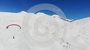 4k man on parachute in winter mountains