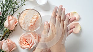 4K. natural skincare concept. woman apply white cream on her hands on white background with jar of cosmetic cream, salt spa scrub