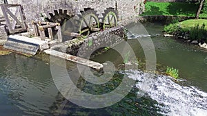 4K. Old water mill still working. Wooden wheels of old mill are rotating. Postojna Cave, Slovenia, Europe