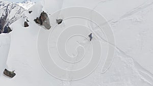 4K person in full winter mountaineering equipment descending from snowy slope with hiking poles in hand. Environment