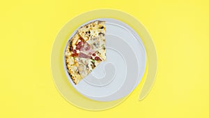 4k Pizza slices disappear one by one from the white plate, then reappear. Yellow background. Ð¡oncept of a popular delicious food.