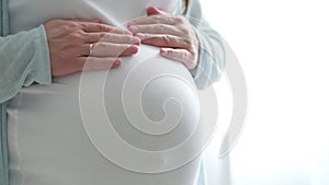 4k Pregnant expectant mother caressing her belly. Woman hands touching her tummy, waiting child. Preparation for