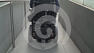 4k resolution back view of a man on electric wheelchair using a ramp. Accessibility concept