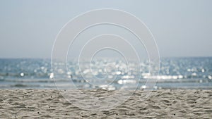 4K. sand with blurred ocean water wave tropical beach bokeh background with sound of the sea, summer vacation and travel concept