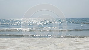 4K. sand with blurred ocean water wave tropical beach bokeh background , summer vacation and travel concept with copy space