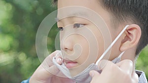 4k Selective focus young Asian boy with getting help to wear face mask