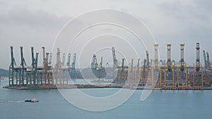 4K. Singapore shipping port with cargo ship sailing slowly on the sea and many container and yellow cranes in background
