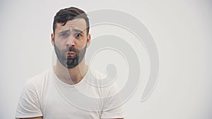 4k slow-motion video of bearded man wearing white t-shirt isolated on white background in studio.