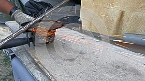 4K slow motion video of a worker sharpening a long metal bar with a radial saw producing hundreds of orange sparks