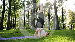 4k slow motion video of yoga and fitness on grass at park. Middle aged smiling woman practicing and doing exercises on