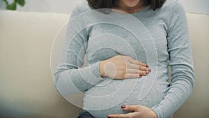 4k slowmotion close up video of pregnant woman wearing casual clothes.