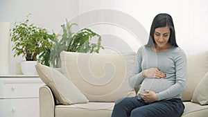 4k slowmotion close up video of pregnant woman wearing casual clothes.