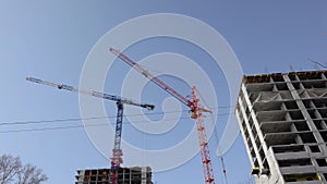 4K Time Lapse Construction cranes move cargo and work on the construction of residential multi-storey buildings
