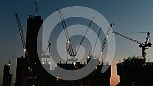 4K Time lapse of silhouette crane working in construction site