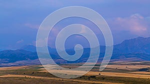 4K Timelapse. Bright clouds over mountain tops and fields