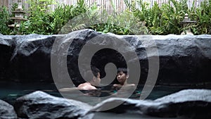 4k Two young Asian boy talk and relax in hot water onzen