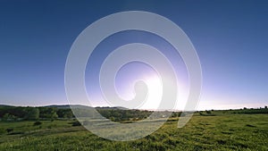 4K UHD mountain meadow timelapse at the summer. Clouds, trees, green grass and sun rays movement.