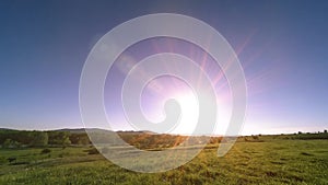 4K UHD mountain meadow timelapse at the summer. Clouds, trees, green grass and sun rays movement.