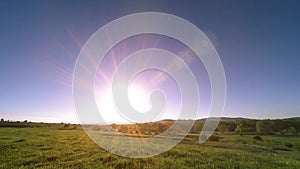 4K UHD mountain meadow timelapse at the summer. Clouds, trees, green grass and sun rays movement.