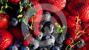 4k. Various colourful berries in glass blow rotation on black background, strawberry, raspberry, blackberry, blueberry, healthy fo