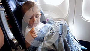 4k video of 2 years old toddler boy eating in airplane during flight