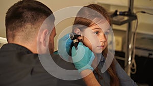 4k video ENT doctor with otoscope. Otoscopy. Pediatrician otolaryngologist looks through otoscope the ears of child