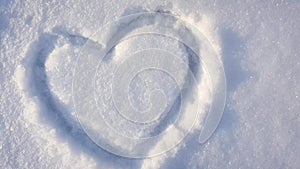 4K video, a heart drawn on the snow in the park. Valentine`s day, slow departure camera