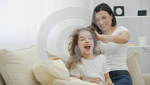 4k video of mother messing up her daughter`s hair.