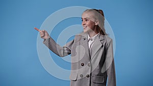 4k video of one girl pointing at left and showing thumb up over blue background.