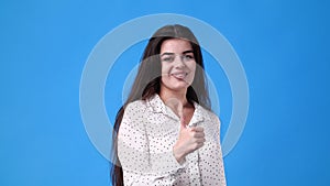 4k video of one girl showing thumb up on blue background.