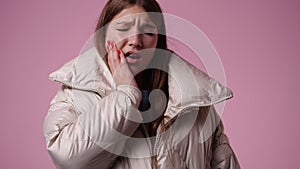 4k video of one girl who suffers from toothaches over pink background.