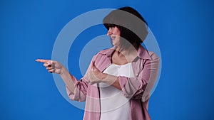 4k video of one woman smiling and showing thumb up on blue background.