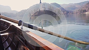 4K video - A paddle in the water on a sunny day - Rowing the boat with island Lake Bled in the background- Lake Bled