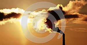 4K video. Steaming cooling towers and smoking industrial stacks against sunset gradient sky