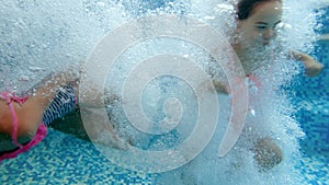 4k video of teenage girl diving under water in swimming pool. View from under the water surface