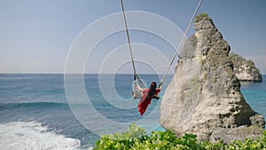 4K video Young woman Playing on the swings at Diamond beach,Bali, indonesia.