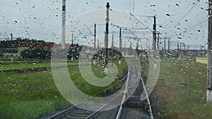 4k, view from the wet front window of a train locomotive to the railway