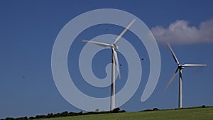 4K wind turbines in blue sky summer day UK