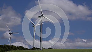 4K wind turbines in farmers field blue sky summer day UK