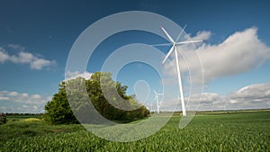 4k Wind turbines generating electricity in a green field of wheat