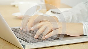 4K. woman hand typing on notebook computer laptop keyboard for working at office workspace