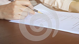 4K. woman reading on paper , flip page and use pencil to marking text on document