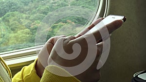 4K Woman using smartphone in the train to do some quick text messaging