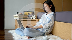 4K. work from home. woman typing on keyboard, working with laptop computer on the floor in bedroom during self isolation