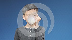 4k Young Asian boy drink milk from a glass