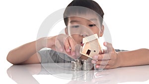 4k Young Asian boy play and adjust mini house on a coin tower to be stable