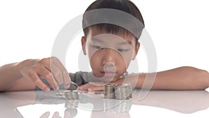 4k Young Asian boy stacking coin tower