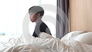 4k Young Asian boy wake up on the bed and stretching