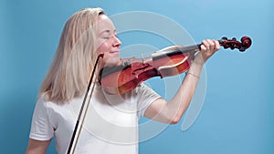 4K. Young caucasian blonde woman playing violin. girl playing the violin